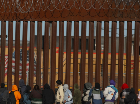 Migrants queue at the border wall to be received by Border Patrol agents after crossing the Rio Grande river from Ciudad Juarez, Chihuahua state, Mexico to El Paso, Texas, US on December 21, 2022. (Herika Martinez/ Getty Images)