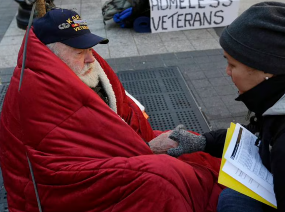 Outreach coordinator from Boston Health Care engages in a conversation with a homeless Korean War veteran on a city sidewalk. November, 2013.